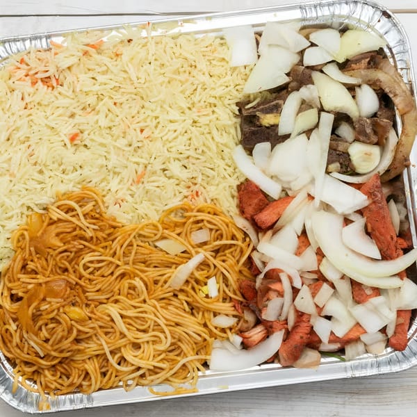 African Paradise Restaurant's large catering tray with rice, spaghetti, and two types of meat with onions.