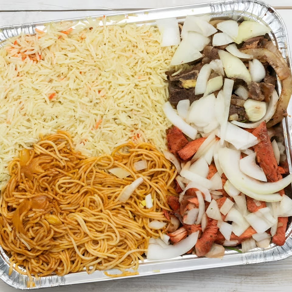 African Paradise Restaurant's large catering tray with rice, spaghetti, and two types of meat with onions.