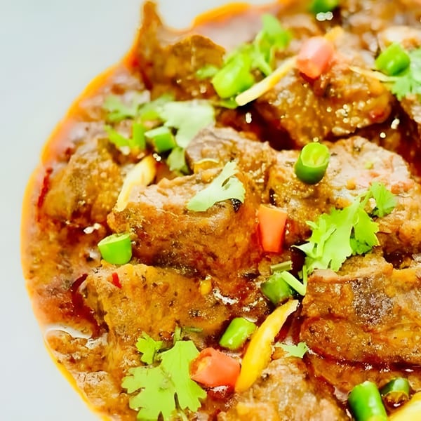 Close-up of African Paradise Restaurant's beef stew, garnished with fresh cilantro, red and green chilies.